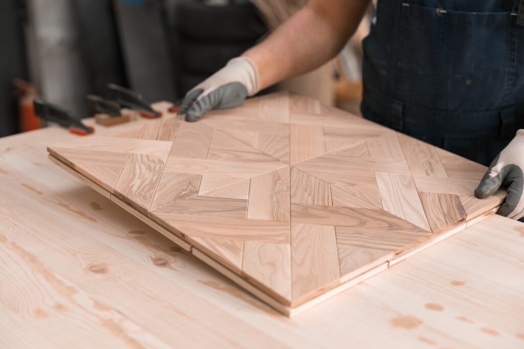 Man holding Wooden floor panel. Handcrafted Flooring Production